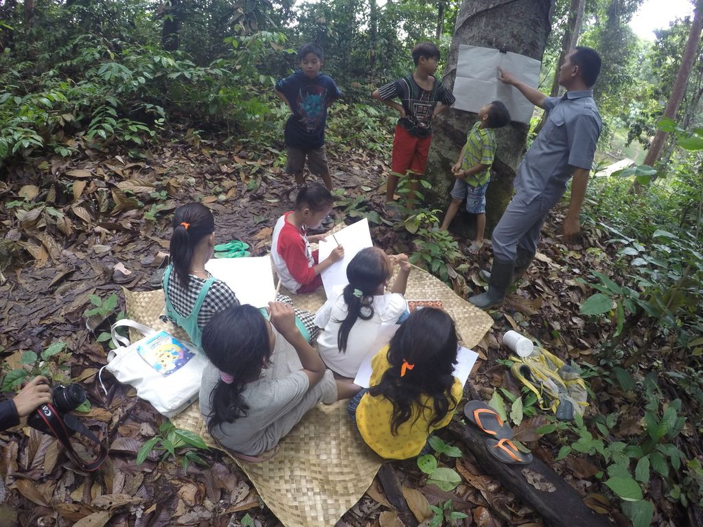 Teguh Rianto (37) membimbing siswa-siswanya belajar di wilayah Kelompang, Hutan Harapan, Kabupaten Batanghari, Jambi, Jumat (26/11/2021). 