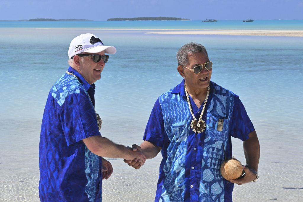 Perdana Menteri Australia Anthony Albanese (kiri) dan Perdana Menteri Tuvalu Kausea Natano berjabat tangan di sela-sela pertemuan para pemimpin negara anggota Forum Kepulauan Pasifik (PIF) di Aitutaki, Kepulauan Cook, Kamis (9/11/2023). Australia dan Tuvalu menyepakati pakta keamanan dan migrasi dalam pertemuan ini. 