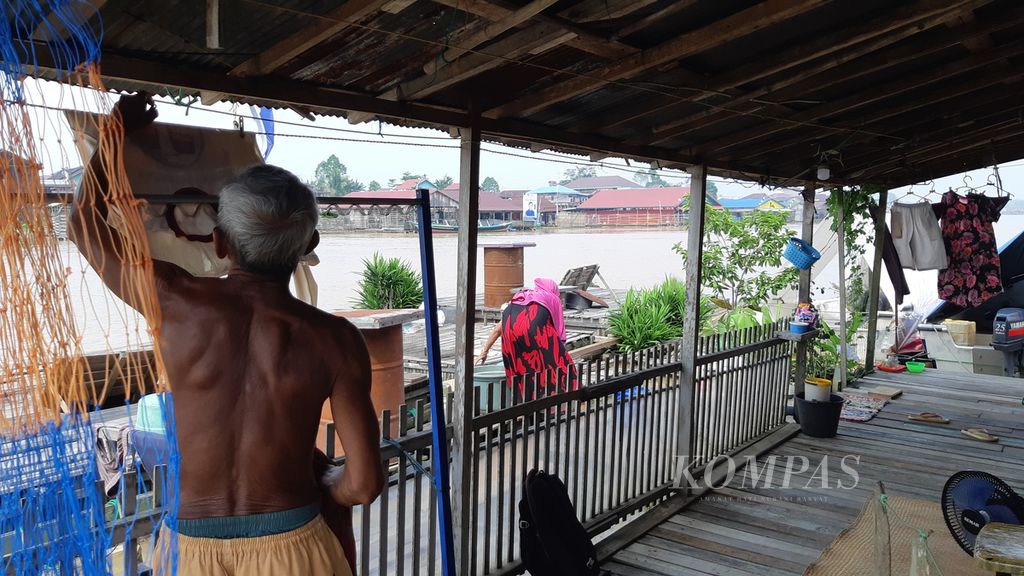 Jaelani (75) beraktivitas di lanting atau rumah apung miliknya di Flamboyan bawah, Kota Palangkaraya, Kalimantan Tengah, Minggu (5/11/2023) siang. Lanting menjadi simbol kemiskinan di Kota Palangkaraya.