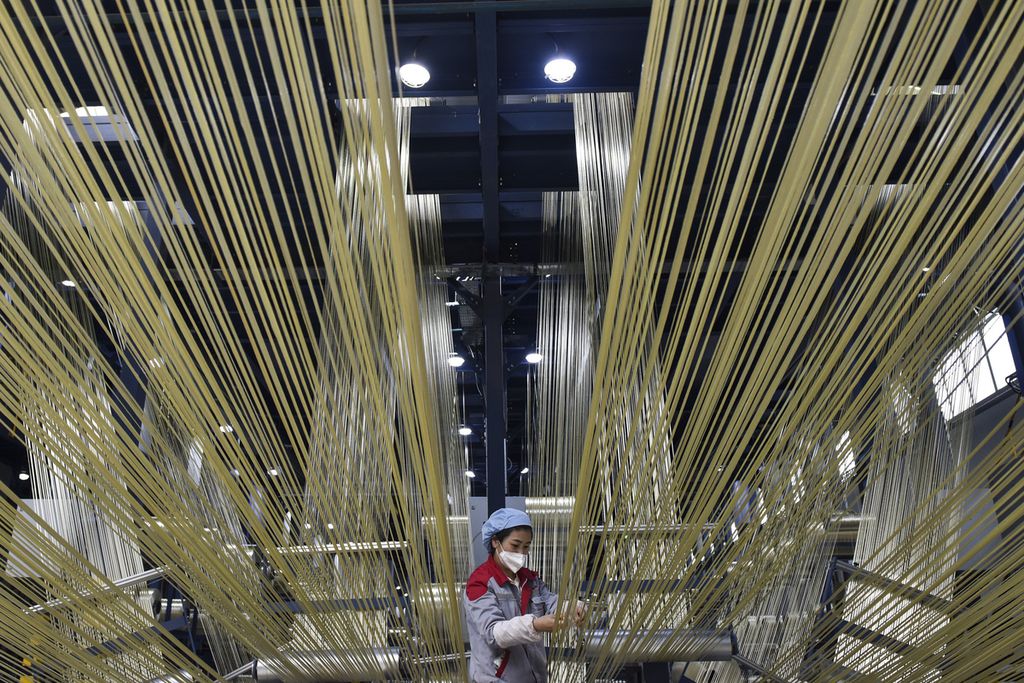 Dalam foto yang dirilis kantor berita Xinhua ini tampak seorang pekerja mengatur filamen mentah di basis produksi Zhongfu Shenying Carbon Fiber Co Ltd di Xining, Provinsi Qinghai, China, 22 Februari 2023. Aktivitas pabrik China meningkat pada Februari seiring dengan ekonomi bangkit kembali setelah berakhirnya kontrol anti-Covid-19. 
