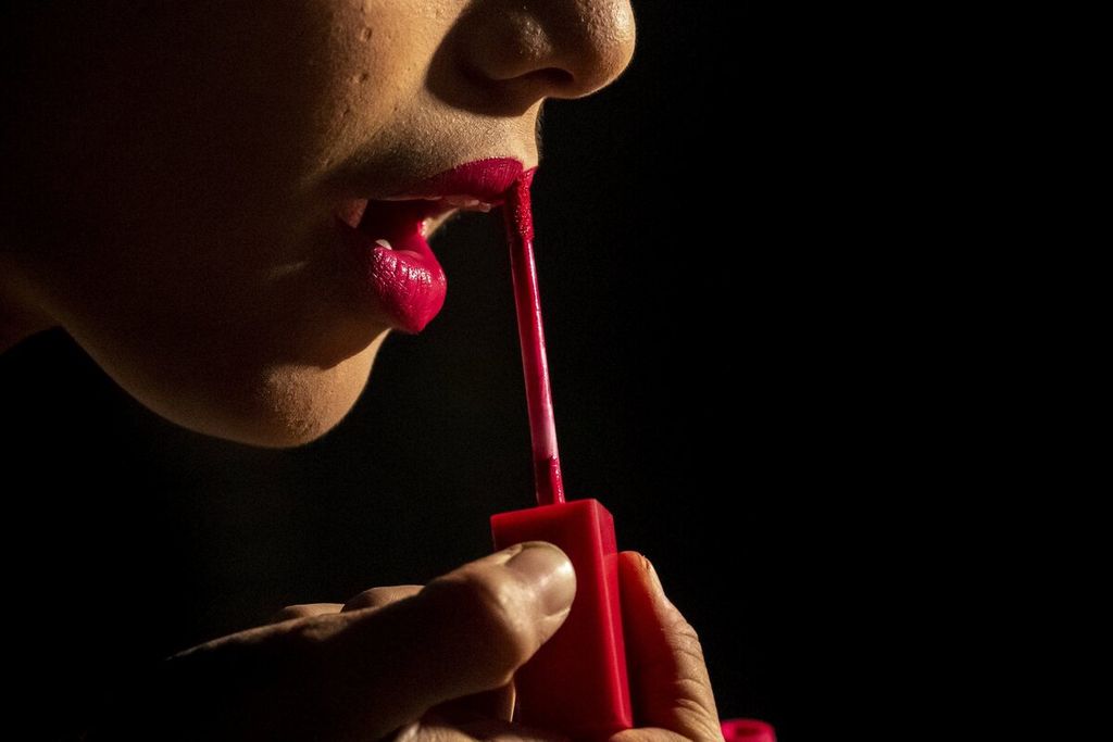 Seorang pemain kelompok teater keliling memulas bibir dengan lipstik sebelum bermain teater di atas panggung, di daerah pedesaan Xetali, kawasan timur Gauhati, India, Rabu, 16 April 2022. 