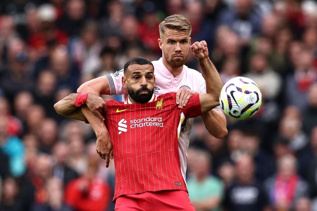 Pemain Liverpool, Mohamed Salah (depan), berebut bola dengan pemain Brentford, Kristoffer Ajer, pada laga Liga Inggris di Stadion Anfield, Liverpool, Minggu (25/8/2024). Liverpool menang 2-0 pada laga itu.