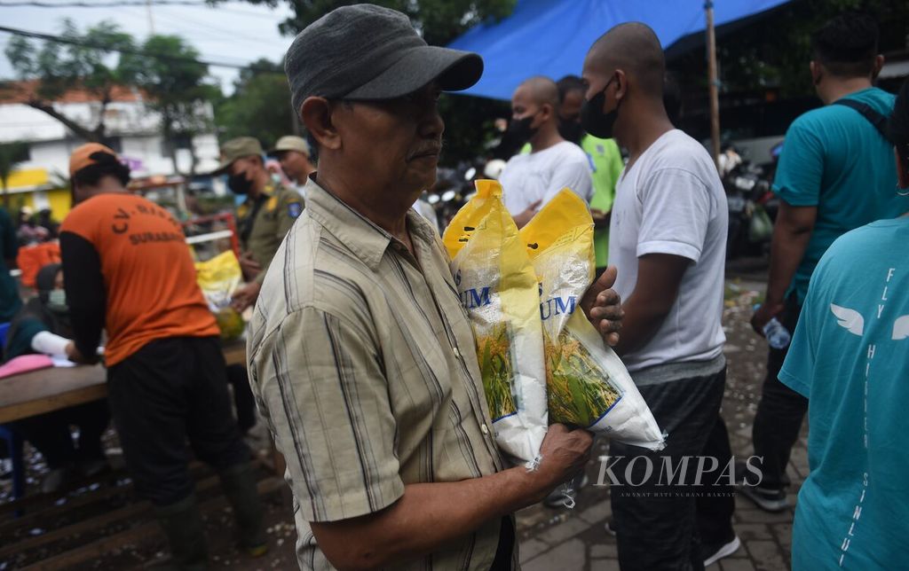 Warga membeli beras medium saat operasi pasar di Pasar Kembang, Surabaya, Minggu (5/2/2023). Beras medium dijual Rp 46.000 per kemasan 5 kg. Pembelian dibatasi 10 kg. 