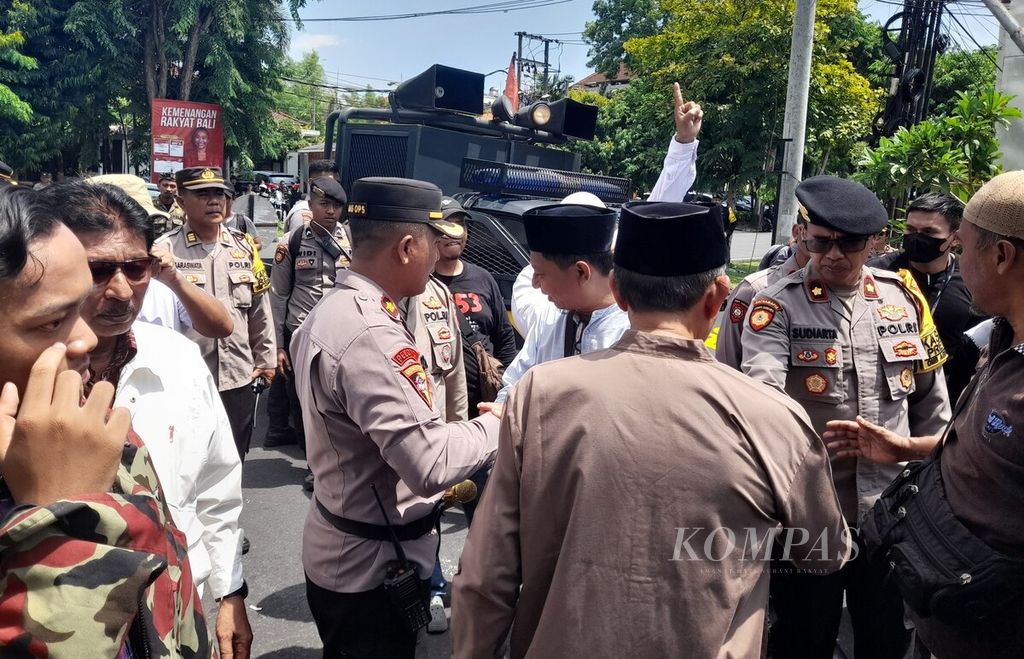 Polisi mengawal unjuk rasa, yang digelar Forum Peduli Keberagaman Bali, di seberang Kantor DPD Perwakilan Provinsi Bali di Kota Denpasar, Kamis (4/1/2024). 