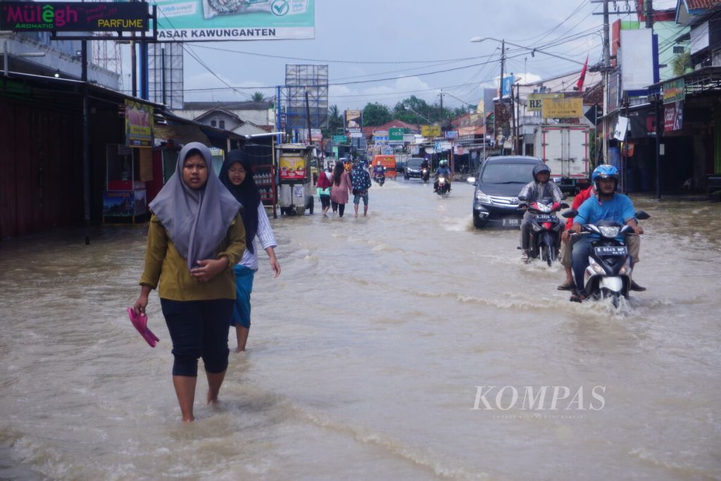 Warga melintasi banjir di Kawunganten, Cilacap, Jawa Tengah, Sabtu (8/10/2022). Di Cilacap, banjir melanda tiga kecamatan, 213 keluarga atau 852 orang kebanjiran.