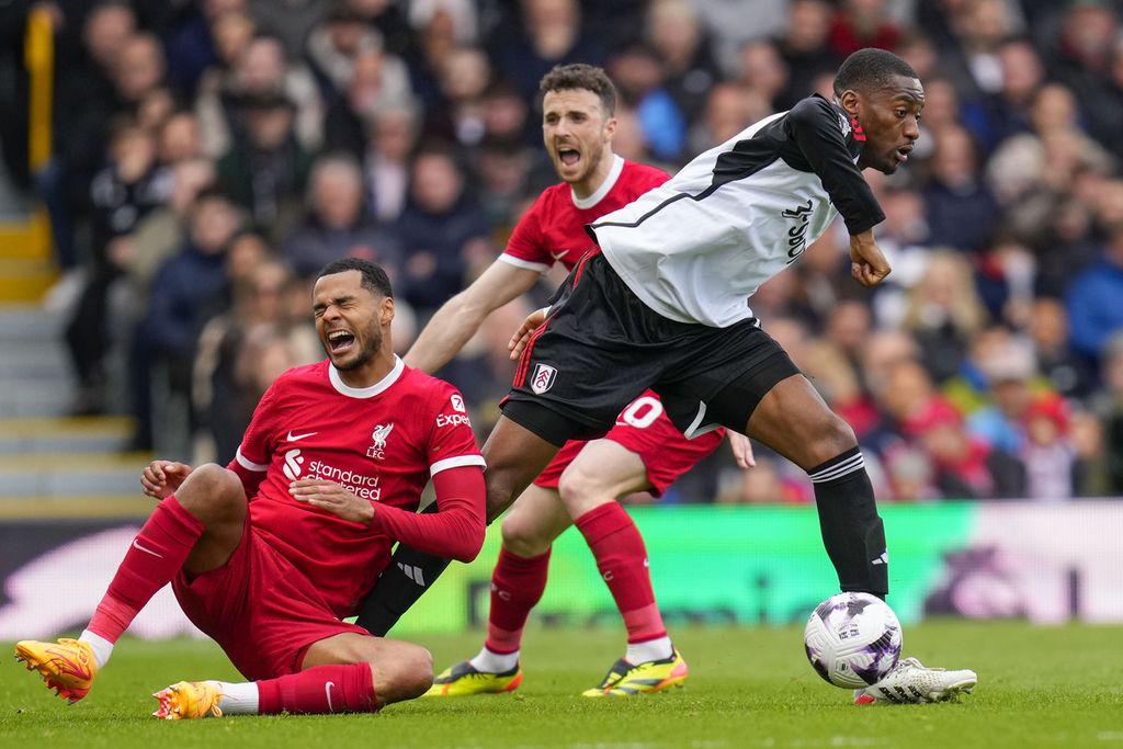 Liverpool winger Cody Gakpo (left) competes for the ball with Fulham defender Tosin Adarabioyo in the English Premier League match at Craven Cottage Stadium, London, on Sunday (21/4/2024) or early Monday morning WIB. Liverpool triumphed over Fulham, 3-1.