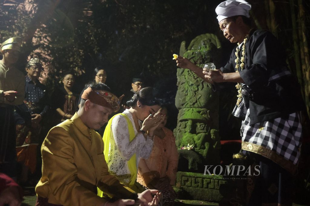 Pasangan pengantin Yakob Jati dan I Gusti Agung Ayu Novitasari melakukan doa bersama saat perayaan Mantenan Bhinneka di Oemah Petruk, Pakem, Sleman, DI Yogyakarta, Selasa (27/9/2022). Acara syukuran pernikahan pasangan pengantin berbeda suku dan agama tersebut dirayakan di tempat itu dengan semangat kebhinnekaan.