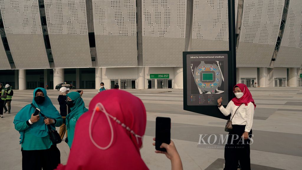 Pengunjung berfoto dengan latar Jakarta International Stadium (JIS) di Kelurahan Papanggo, Tanjung Priok, Jakarta Utara, Selasa (29/3/2022).