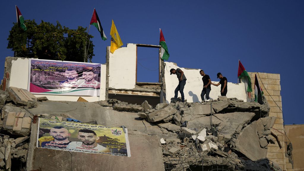 Warga Palestina memanjat puing-puing rumah Subhi Sbeihat yang hancur karena serangan pasukan Israel. Subhi Sbeihat besama warga lain Asad Rifai, diduga melakukan serangan mematikan terhadap warga Israel di Kota Elad, Tel Aviv, pada Mei 2022. 