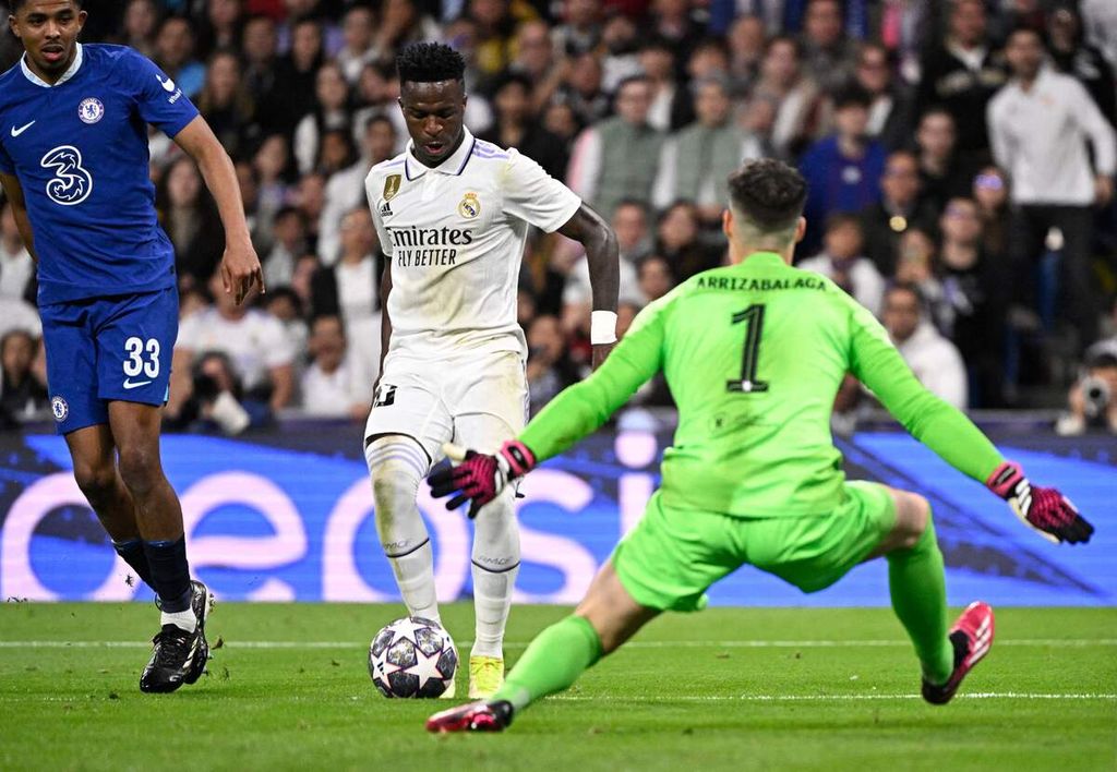 Pemain Real Madrid Vinicius Junior (tengah) berusaha mencetak gol ke gawang Chelsea yang djaga kiper Kepa Arrizabalaga pada laga pertama babak perempat final Liga Champions di Stadion Santiago Bernabeu, Madrid, Spanyol. Kamis (12/4/2023). Real Madrid menang 2-0 pada laga itu.