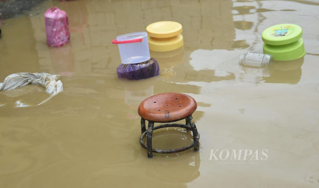 warga meletakkan barang saat banjir di Desa Blega, Kecamatan Blega, Kabupaten Bangkalan, Jawa Timur, Minggu (1/1/2023).