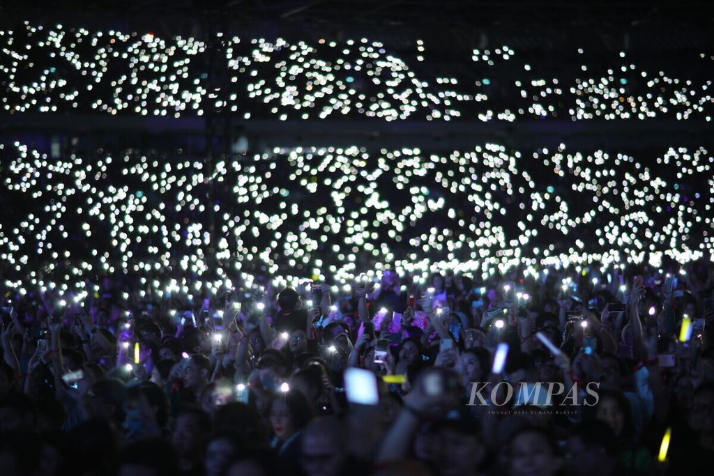 Penonton menyalakan lampu telepon seluler mereka saat penyanyi pop asal Inggris, Ed Sheeran, menggelar konser di Stadion Utama Gelora Bung Karno, Senayan, Jakarta, Jumat (3/5/2019).