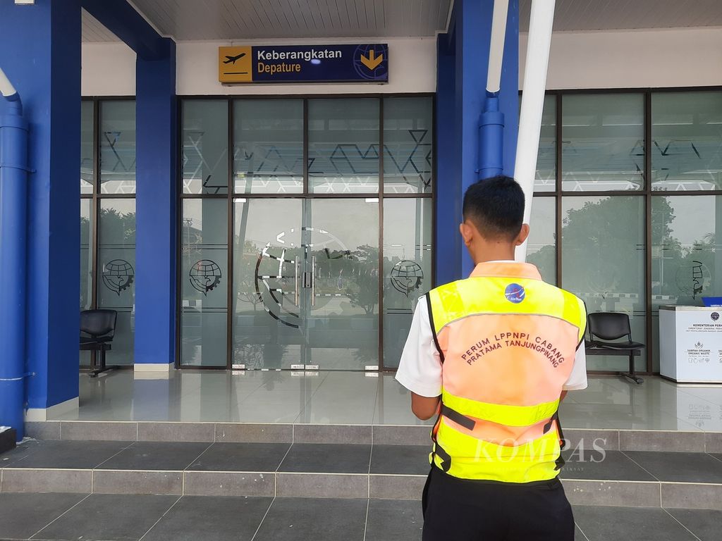 Seorang petugas bersiaga di depan pintu keberangkatan Bandara Raja Haji Abdullah, Kabupaten Karimun, Kepulauan Riau, Minggu (13/8/2023). 