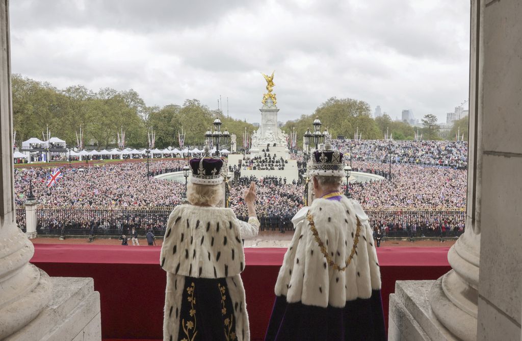 Raja Inggris Charles III (kanan) dan Permaisuri Camilla melambaikan tangan ke arah warga dari balkon Istana Buckingham seusai upacara penobatan keduanya di London, Sabtu (6/5/2023). 