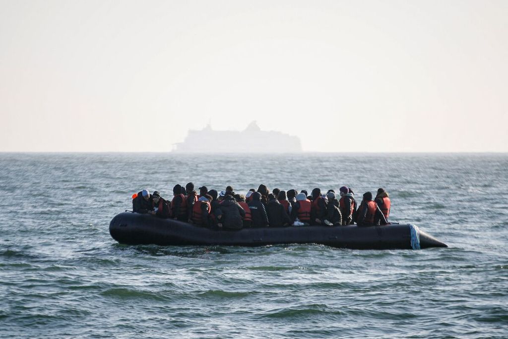 Para migran menanti bantuan dari perahu Abeille Languedoc setelah mesin perahu mereka mati di perairan Perancis dalam upaya pelayaran ilegal menyeberangi Kanal Inggris-Perancis menuju Inggris di perairan lepas pantai Boulogne-sur-Mer, Perancis utara, 9 Mei 2022. 