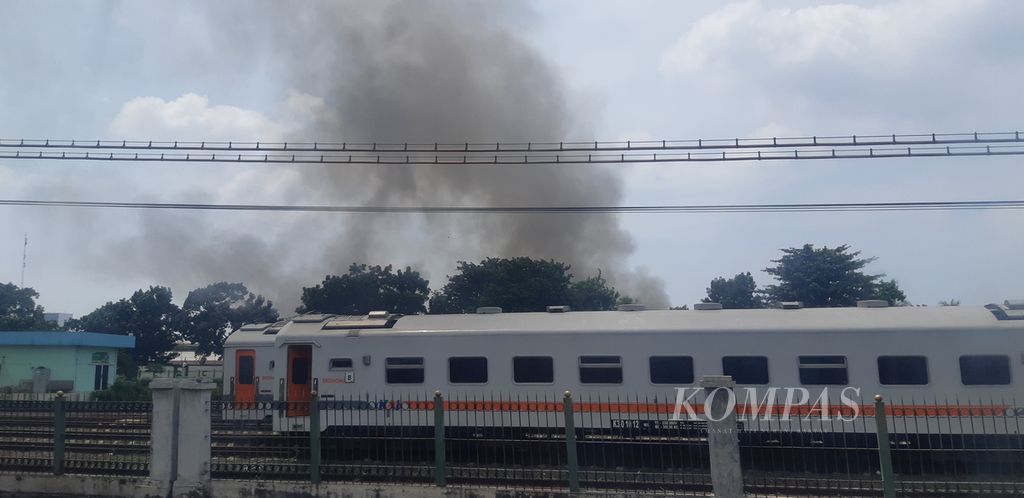 Asap hitam dari lokasi kebakaran di Gudang Indo Grosir Pasar Induk Cipinang, Kecamatan Pulogadung, dilihat dari Depo Lokomotif Kereta KAI di Jakarta Timur, Selasa (21/3/2023) siang.