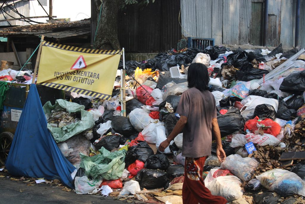 Salah satu warga melewati tumpukan sampah yang mulai menggunung di tempat pembuangan sampah di Kecamatan Sumur Bandung, Kota Bandung, Jawa Barat, Kamis (31/8/2023).