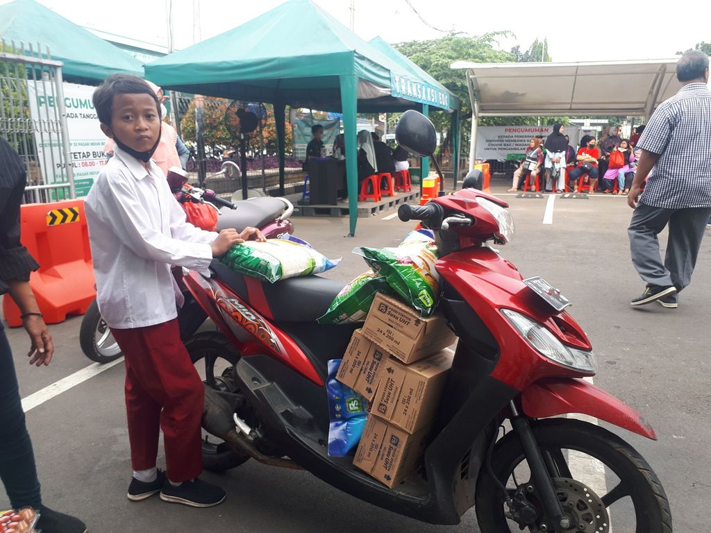 Warga menumpuk bahan pokok bantuan pangan bersubsidi di Food Station Tjipinang Raya, Pisangan Timur, Pulo Gadung, Jakarta Timur, Jumat (2/12/2022).