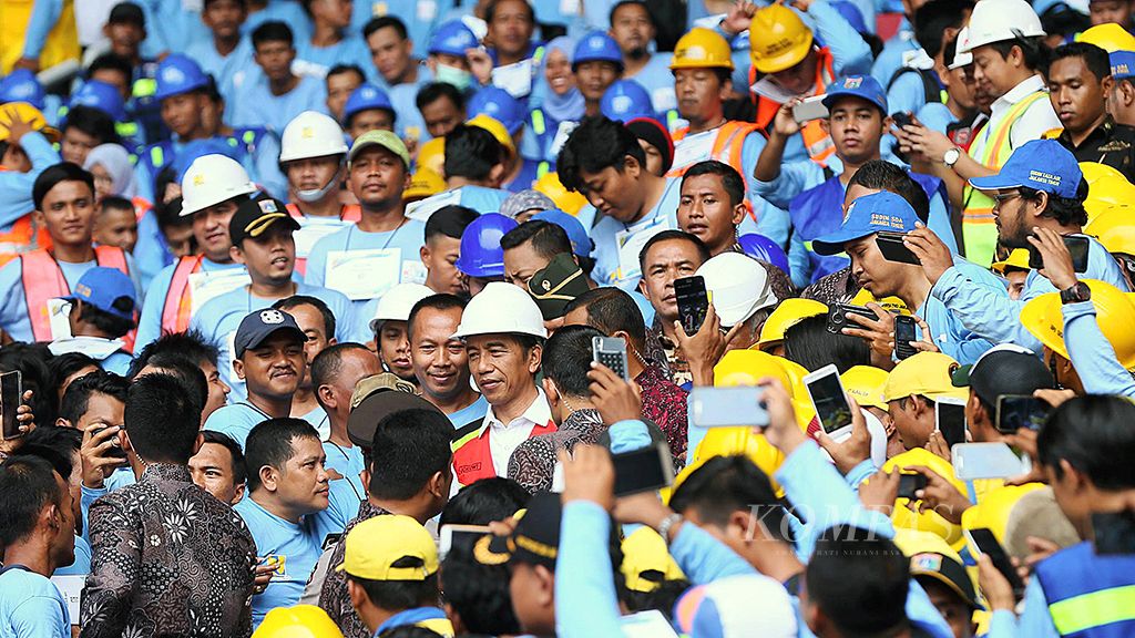 Presiden Joko Widodo menyapa pekerja konstruksi usai meresmikan pembukaan percepatan sertifikasi tenaga kerja konstruksi secara serempak di Indonesia yang digelar di Stadion Gelora Bung Karno, senayan, Jakarta, Kamis (19/10). Dalam sambutannya Presiden menegaskan bahwa sertifikasi itu akan meningkatkan kompetensi dan kesejahteraan pekerja konstruksi.<br /> Kompas/Wisnu Widiantoro (NUT)<br /> 19-10-2017