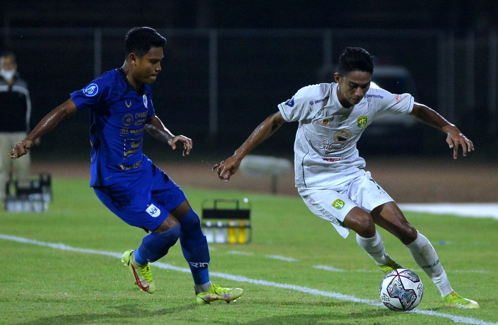 Pemain Persebaya Surabaya, Marselino Ferdinan (kanan), berebut bola dengan pemain PSIS Semarang, Fandi Eko Utomo (kanan),pada laga Liga 1 Indonesia di Stadion I Gusti Ngurah Rai, Denpasar, Bali, Rabu (2/2/2022). 
