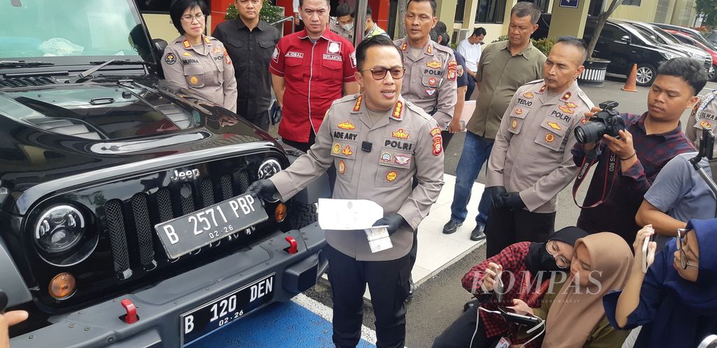 Kepala Kepolisian Resor Metro Jakarta Selatan Komisaris Besar Ade Ary, di Jakarta, Rabu (22/2/2023), memegang pelat nomor asli sebuah mobil Jeep di atas pelat nomor polisi palsu yang dibawa MDS (20) saat melakukan perbuatan pidana.