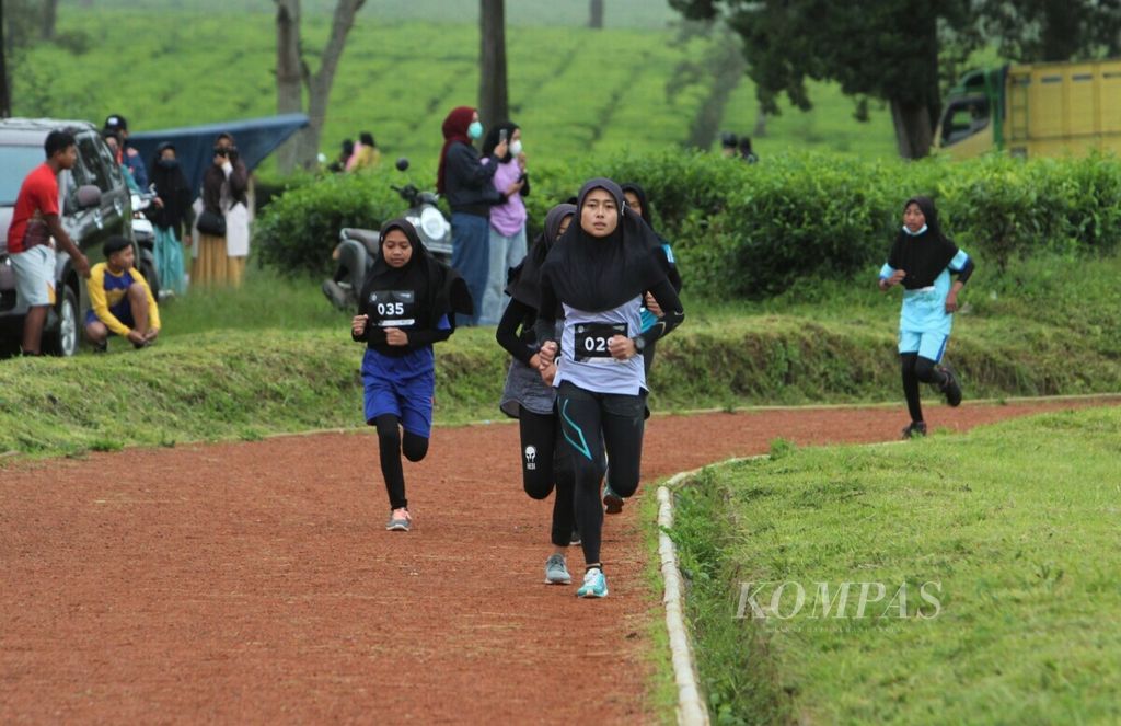 Peserta Pangalengan Track Race 2020 berlomba di Lapangan Babakan Tanara yang terletak di Perkebunan Teh Malabar, Pangalengan, Kabupaten Bandung, Jawa Barat, Sabtu (19/12/2020). Lomba yang diadakan Agung Mulyawan Track Club (AMTC) itu melibatkan guru-guru olahraga setempat untuk memantau bakat pelari lokal. 