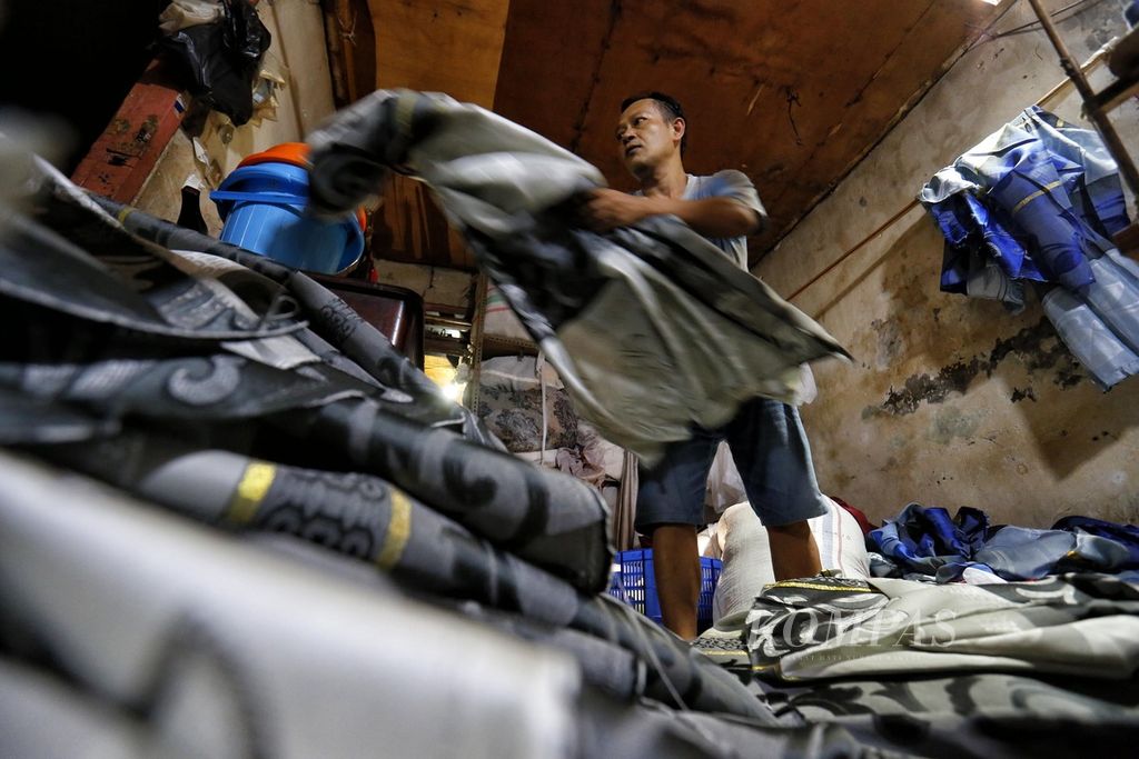 Pekerja sedang menyelesaikan pembuatan kain gorden di usaha kecil skala rumahan milik Masdudin di kawasan Tanah Abang, Jakarta, Selasa (30/5/2023). 