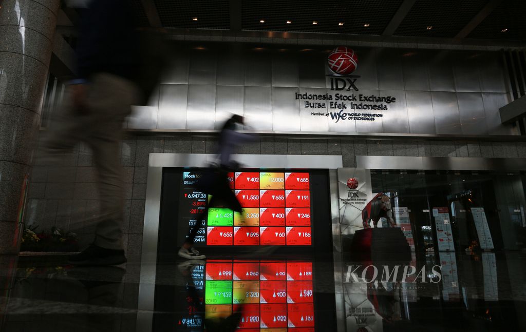 Karyawan melintas di monitor yang memperlihatkan pergerakan indeks di Bursa Efek Indonesia di Jakarta, Senin (9/5/2022). 