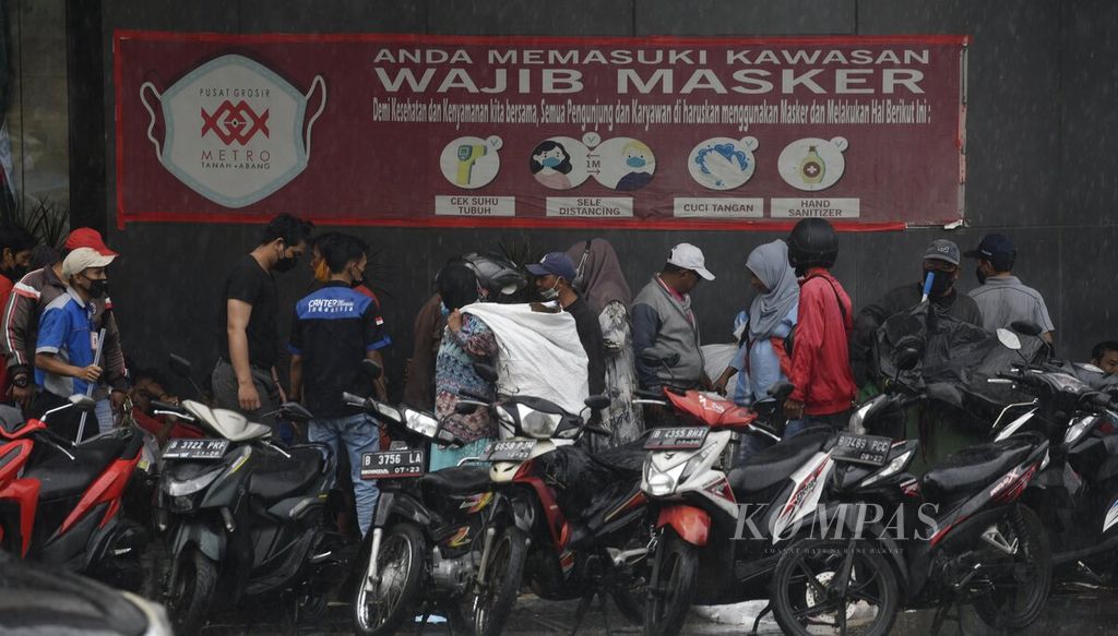 Warga berada di depan pertokoan di kawasan Tanah Abang, Jakarta, Kamis (17/2/2022). Di wilayah DKI Jakarta terjadi tren penurunan kasus dalam empat hari terakhir, tetapi lonjakan kasus diperkirakan akan terjadi di luar wilayah Jawa-Bali dalam beberapa pekan ke depan. 