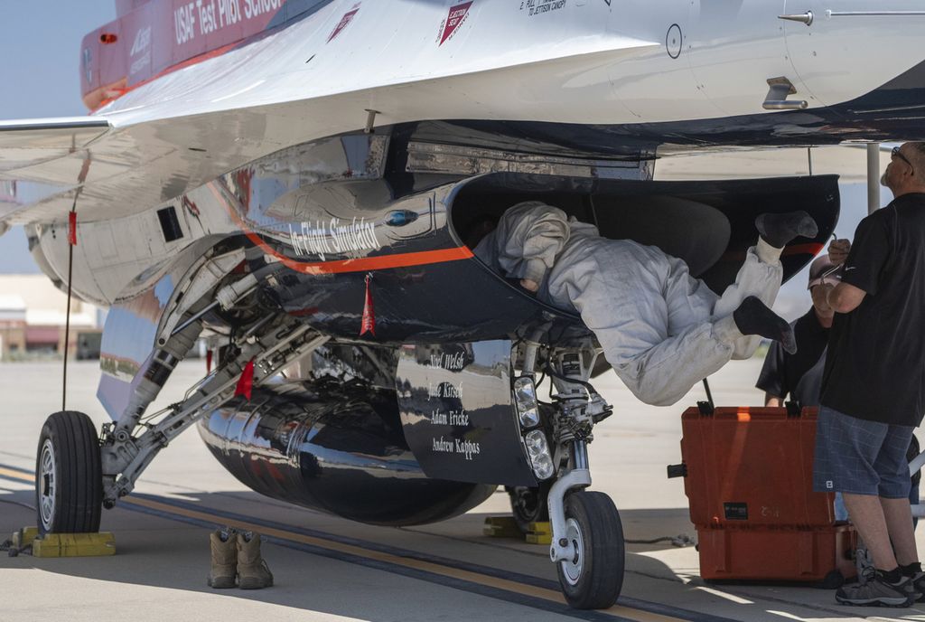 United States Air Force technicians inspect the X-62A, an F-16 jet equipped with artificial intelligence, at Andrews Air Base, California, USA.
