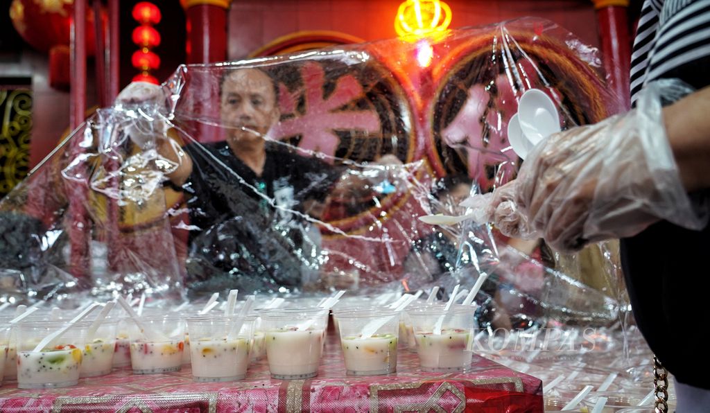 Umat Wihara Dharma Bakti, Glodok, Jakarta, menutup makanan untuk dibagikan sebagai takjil buka puasa dengan plastik agar tetap bersih, Minggu (17/3/2024). 