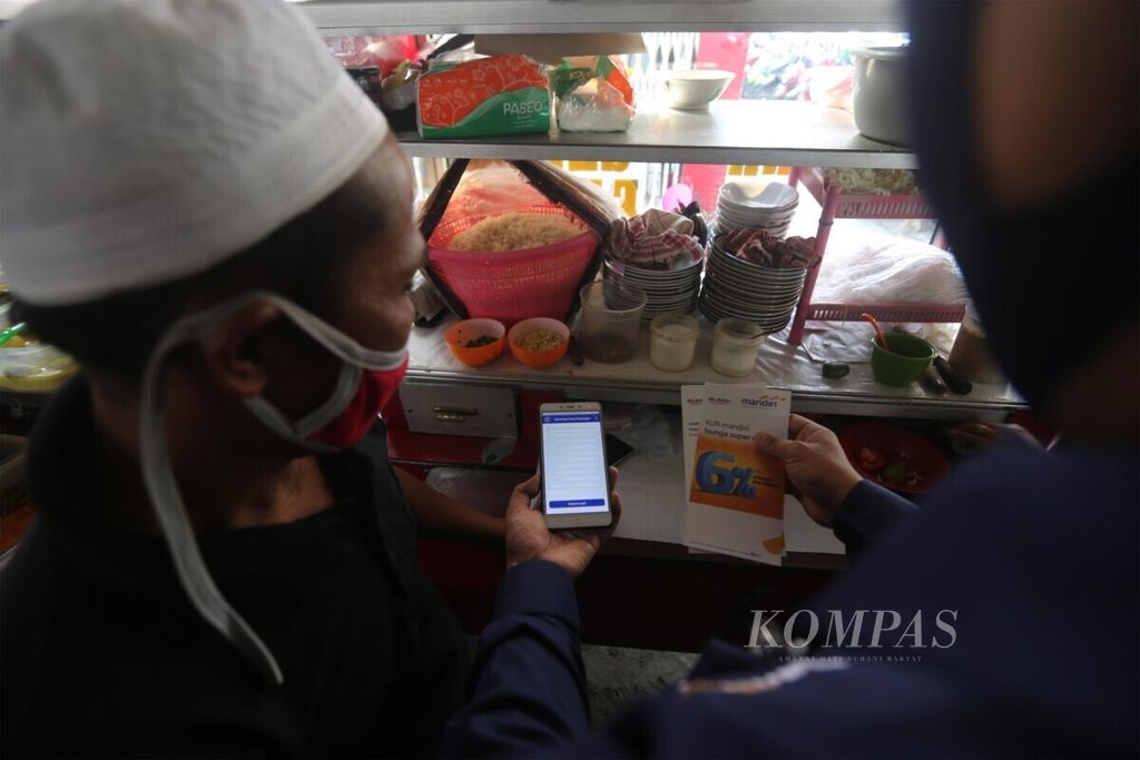 Pedagang kuliner di Pasar Mayestik, Jakarta, mendengarkan penjelasan tenaga pemasar Bank Mandiri tentang aplikasi kredit mikro daring milik bank tersebut, Senin (29/6/2020). 