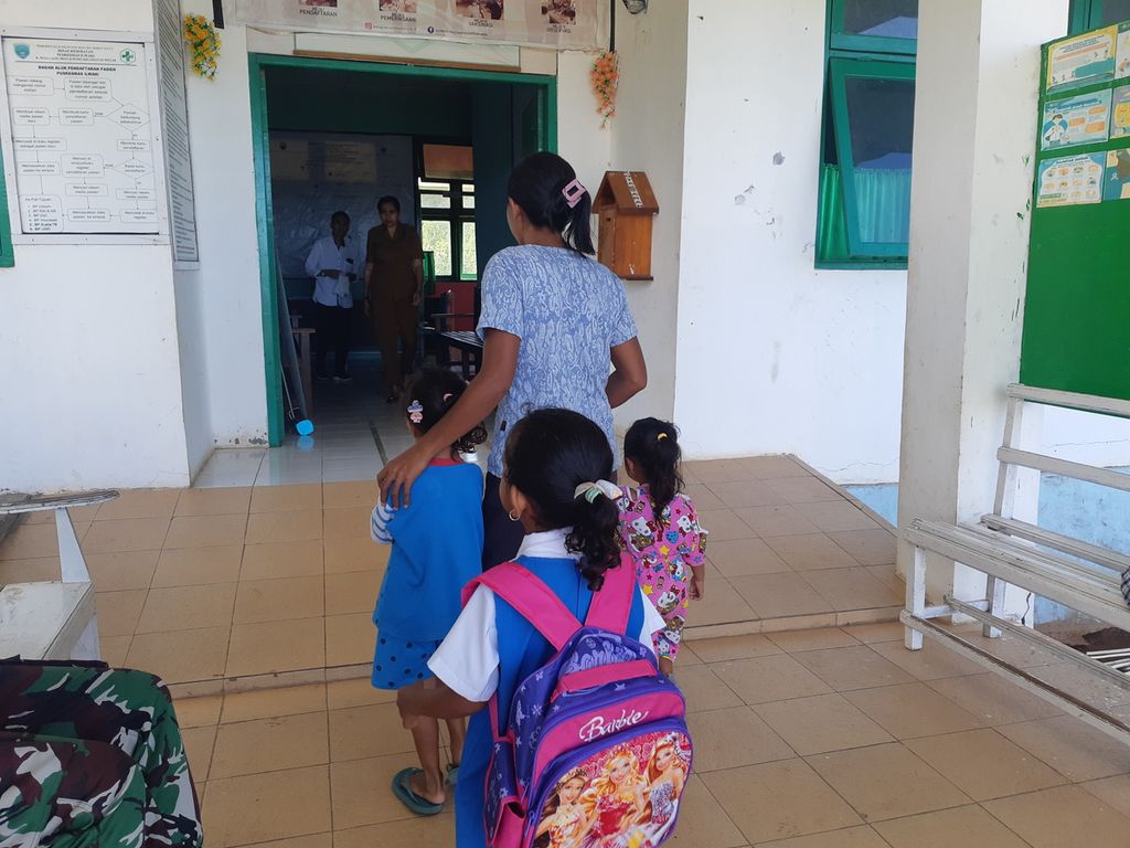 Seorang pengasuh taman kanak-kanak membawa muridnya yang terluka ke Puskesmas Ilwaki, Pulau Wetar, Kabupaten Maluku Barat Daya, Maluku, pada Senin (8/8/2022).