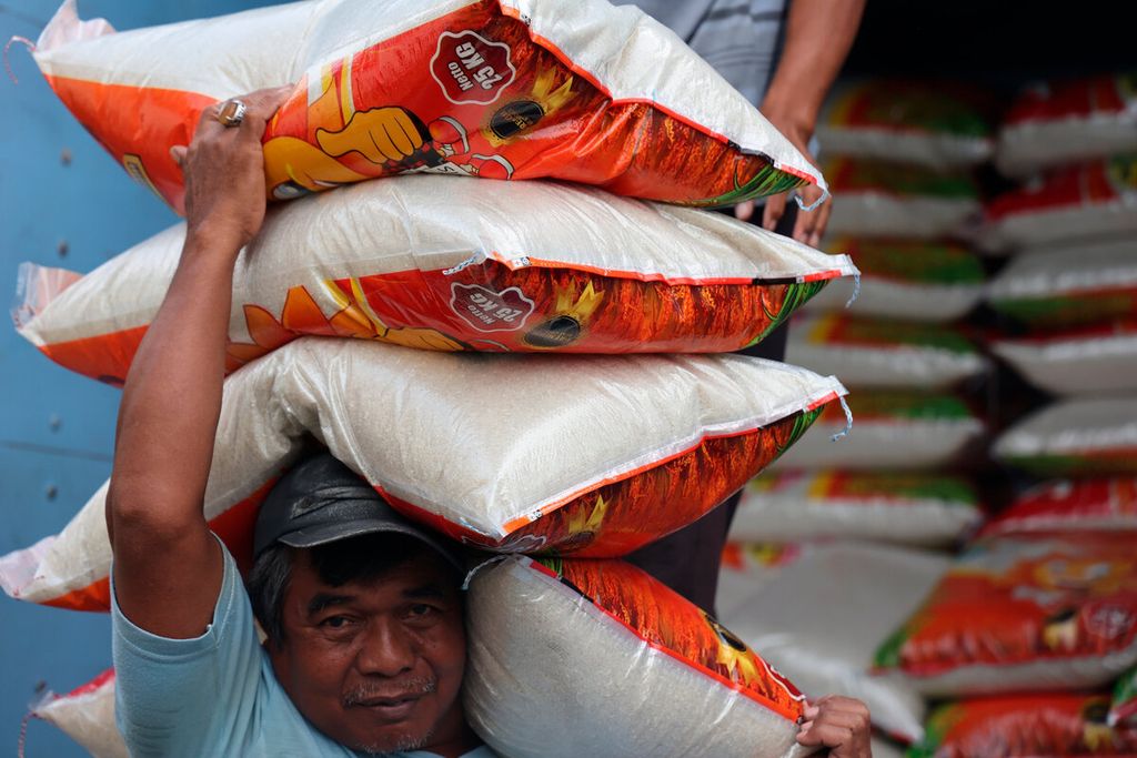 Buruh panggul mengusung beras dari atas truk ke gudang penyimpanan milik pedagang di Pasar Dargo, Kota Semarang, Jawa Tengah, Rabu (22/2/2023). 