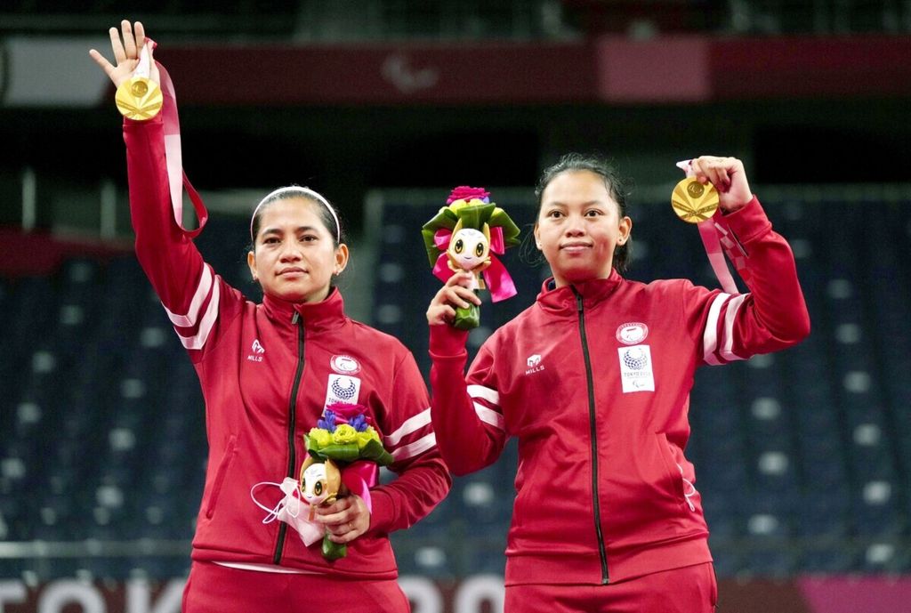 Leani Ratri Oktila (kiri) dan Khalimatus Sadiyah berpose dengan medali emas ganda putri bulu tangkis SL3-SU5 yang diraihnya di Paralimpiade Tokyo 2020, Sabtu (4/9/2021), di Tokyo, Jepang. 