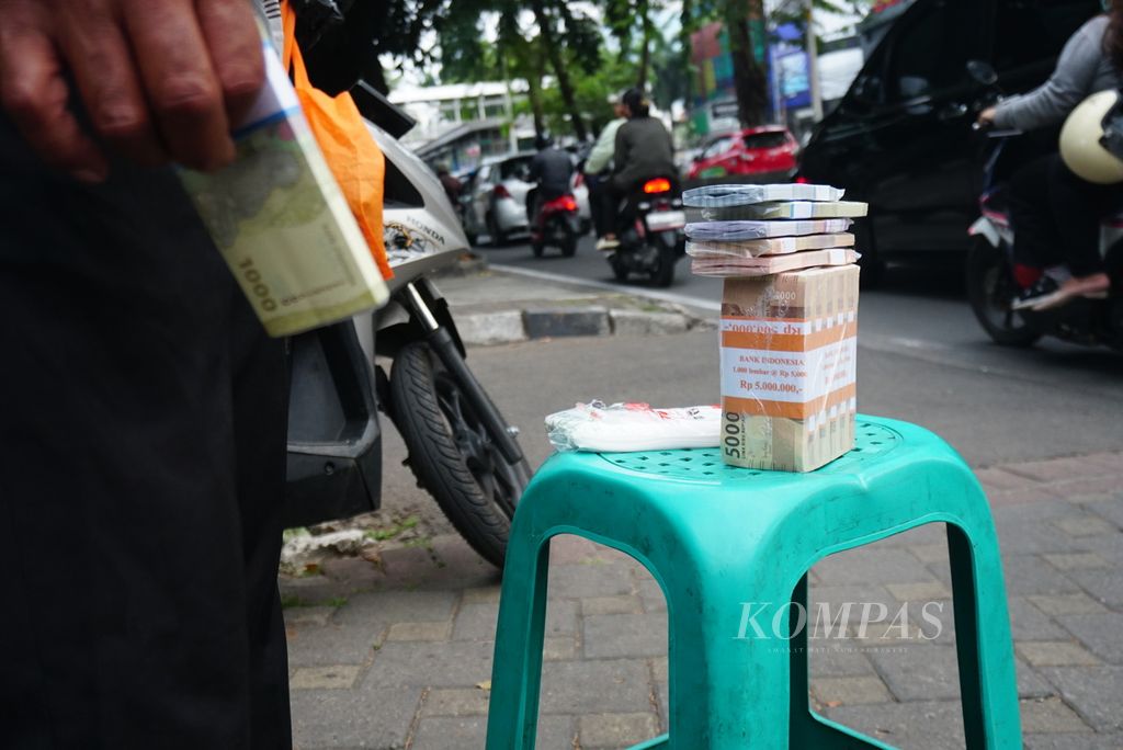 Pecahan uang kertas Rp 1.000 sampai Rp 20.000 dipajang di tepi jalan di daerah Kebayoran Lama, Jakarta Selatan, Selasa (18/4/2023). Para penyedia jasa penukaran uang mengambil untung Rp 10.000 untuk setiap Rp 100.000 yang ditukarkan masyarakat.