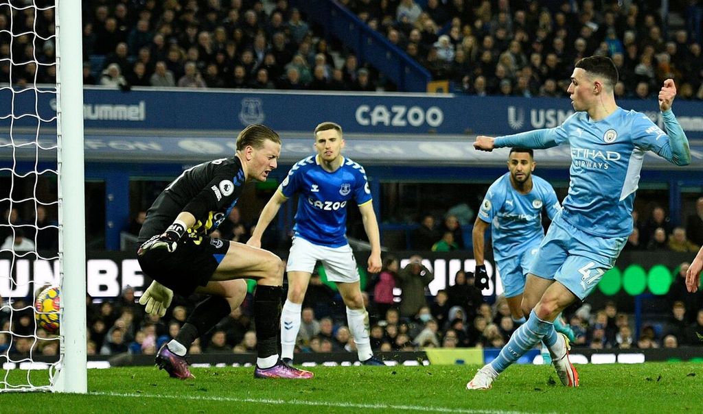 Pemain Manchester City, Phil Foden (kanan), mencetak gol bagi timnya saat melawan Everton pada laga Liga Inggris di Stadion Goodison Park, Liverpool, Minggu (27/2/2022) dini hari WIB. City memenangi laga dengan skor 1-0. 