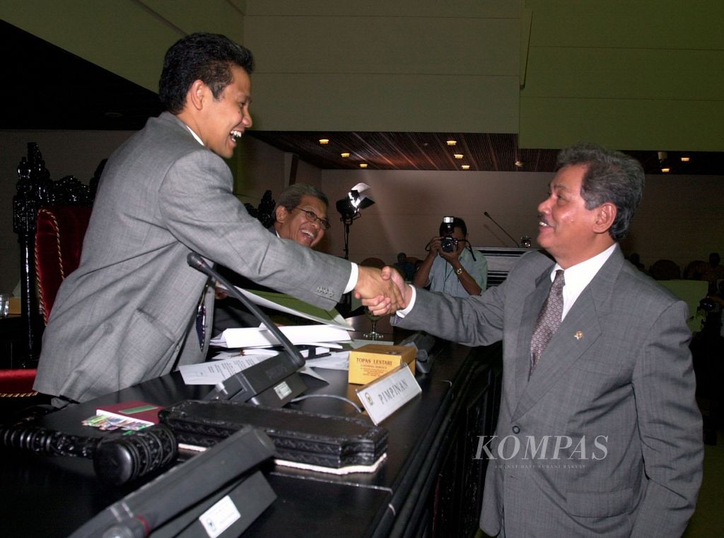 Wakil Ketua DPR Muhaimin Iskandar (kiri), disaksikan Wakil Ketua DPR AM Fatwa (berkacamata), berjabat tangan dengan Menteri Pendidikan Nasional Abdul Malik Fadjar yang mewakili pemerintah dalam Rapat Paripurna DPR di Ruang Nusantara V, Gedung MPR/DPR, Jakarta, 11 Juni 2003 malam, 