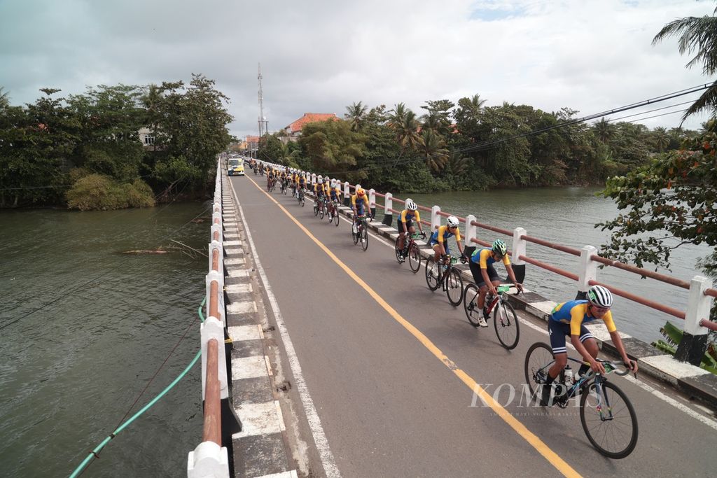 Para pebalap melintasi jembatan Ciujung, Sindangbarang, Cianjur, Jawa Barat, pada etape pertama Cycling de Jabar 2023, Sabtu (8/7/2023). 
