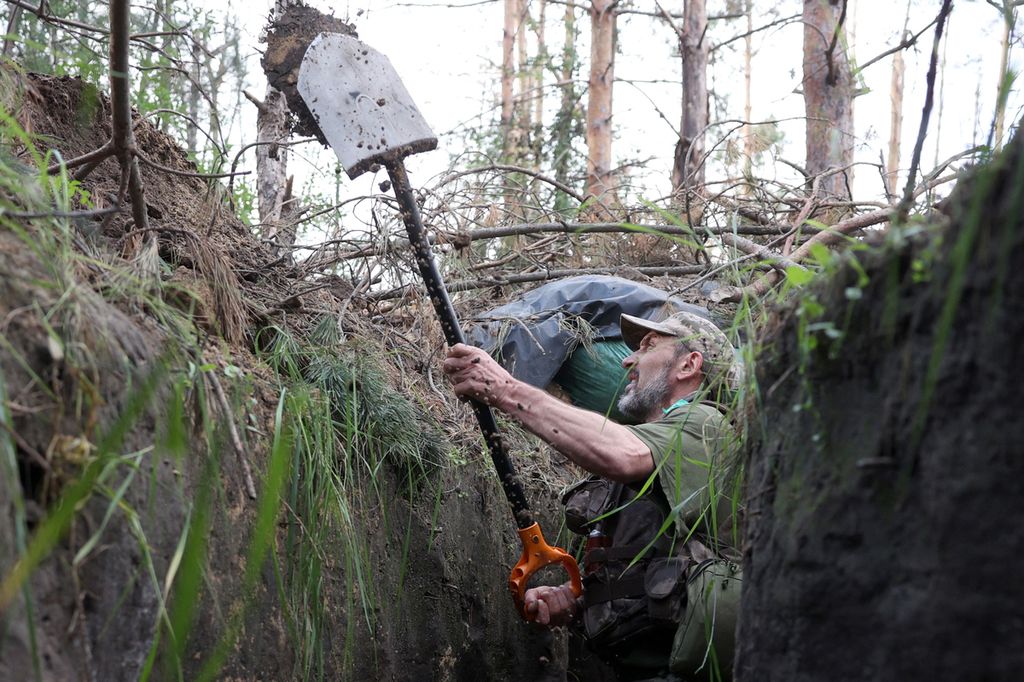 Seorang anggota militer Ukraina menggali parit untuk perlindungan di dekat Kota Kreminna, wilayah Luhansk, 17 Juni 2023. 