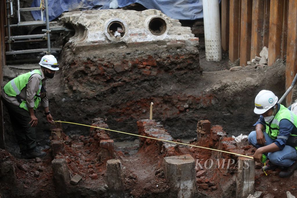Anggota tim konsultan arkeolog subkontraktor PT MRT Jakarta melakukan pengukuran di area temuan artefak struktur fondasi saluran air dari pipa terakota di lokasi proyek MRT Jakarta fase 2A CP-203 Glodok-Kota di kawasan Glodok, Jakarta Barat, Kamis (3/11/2022). 