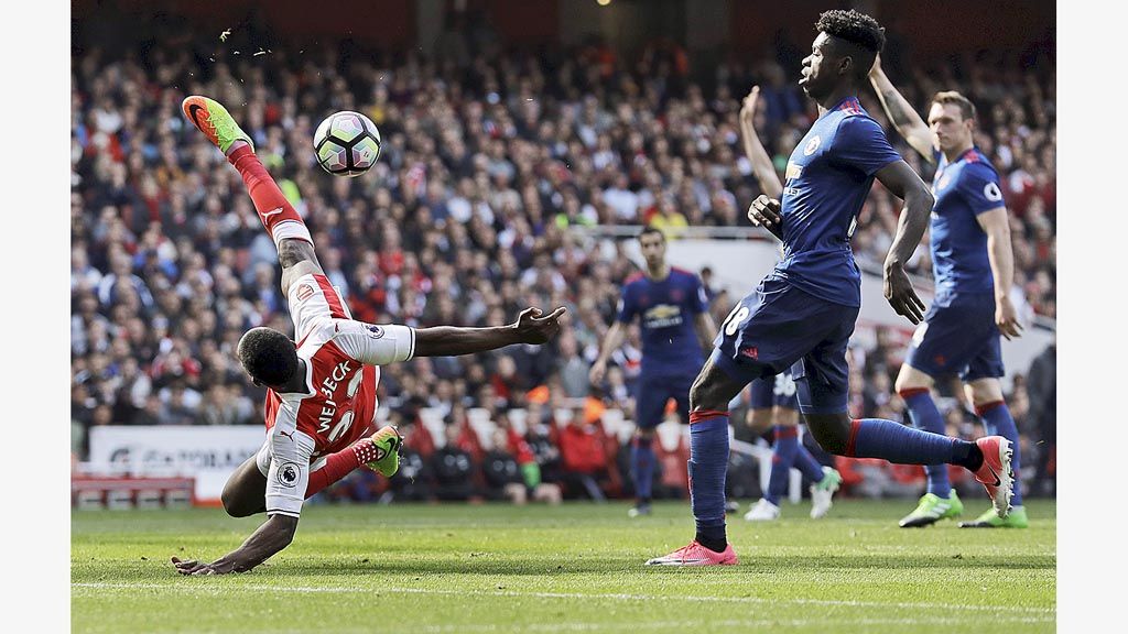 Striker Arsenal,  Danny Welbeck, gagal melepaskan tendangan salto saat melawan Manchester United pada laga Liga Inggris di Stadion Emirates, London, Minggu (7/5). Welbeck, yang pernah membela Manchester United, menceploskan satu gol dan mengantar Arsenal menang 2-0.