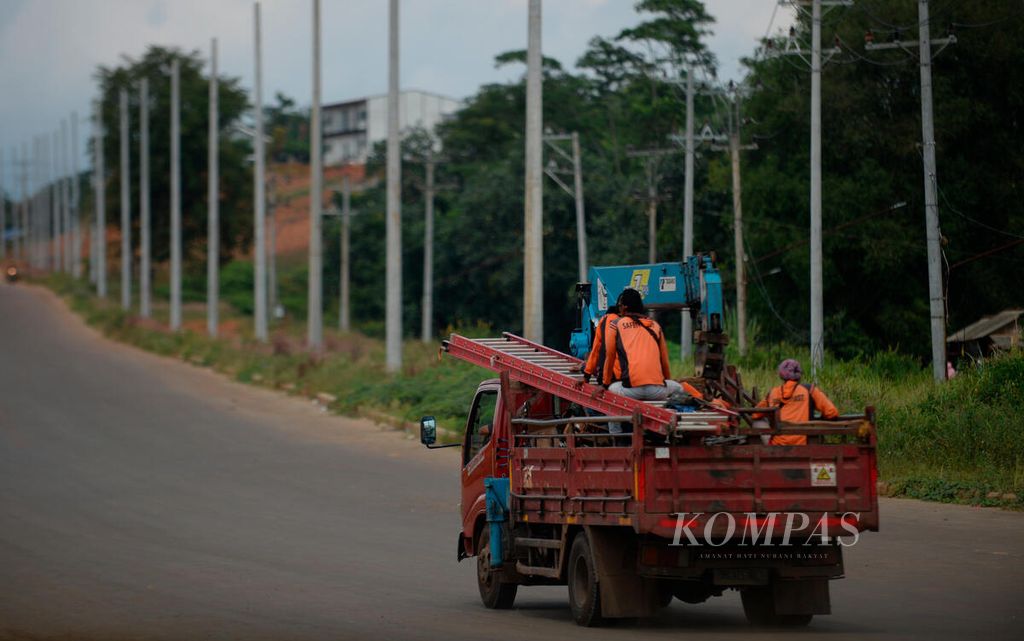 Pekerja melintas dengan menggunakan truk untuk menyiapkan infrastruktur jaringan listrik bagi kawasan industri di Kecamatan Tulis, Kabupaten Batang, Jawa Tengah, Senin (13/6/2022). 