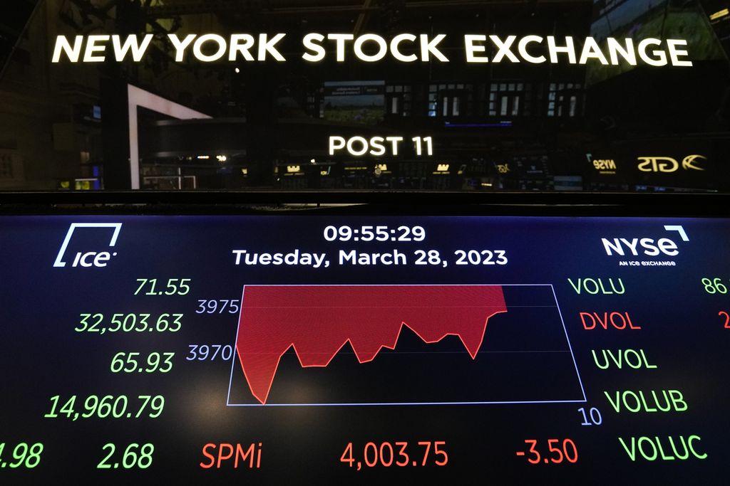 Sebuah layar menayangkan informasi di lantai Bursa Efek New York di New York, Selasa (28/3/2023). (AP Photo/Seth Wenig)