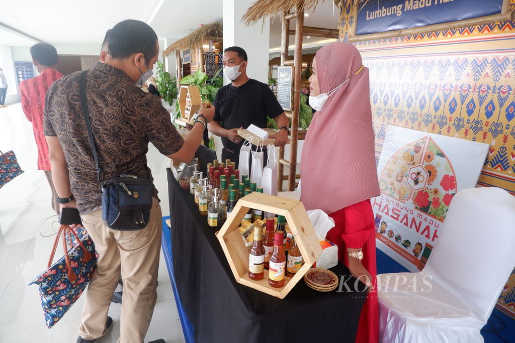 Peserta membeli produk UMKM yang membuka gerai pada Konferensi Internasional Mandalika Infinity Experiences of Nature and Sport Tourism yang diselenggarakan Kementerian Pariwisata dan Ekonomi Kreatif/Badan Pariwisata dan Ekonomi Kreatif bekerja sama dengan harian <i>Kompas</i> di kawasan Kuta Mandalika, Pujut, Lombok Tengah, Nusa Tenggara Barat, Rabu (1/12/2021).