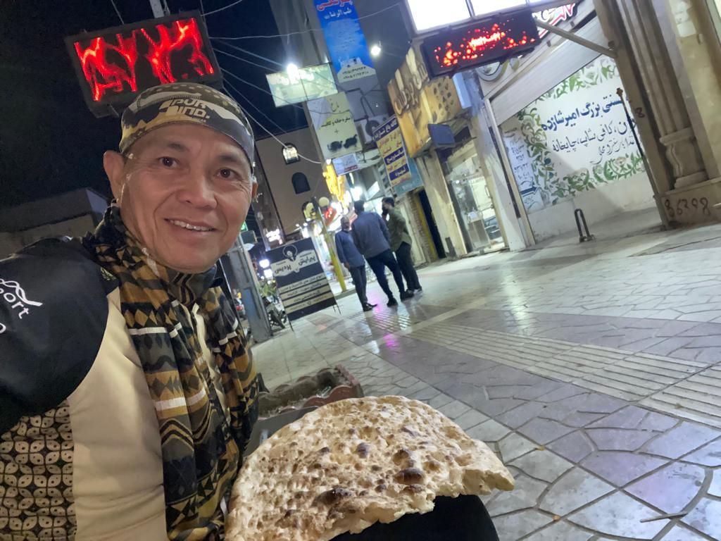 Pesepeda asal Indonesia yang melakukan perjalanan Jakarta-Paris telah tiba di Iran dan hendak memasuki Irak. Royke tengah makan roti di Zahedan.