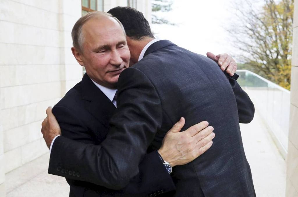 Presiden Rusia Vladimir Putin (kiri) memeluk Presiden Bashar al-Assad di Bocharov Ruchei di kawasan Sochi, Laut Hitam, Rusia, Senin (20/11/2017). 