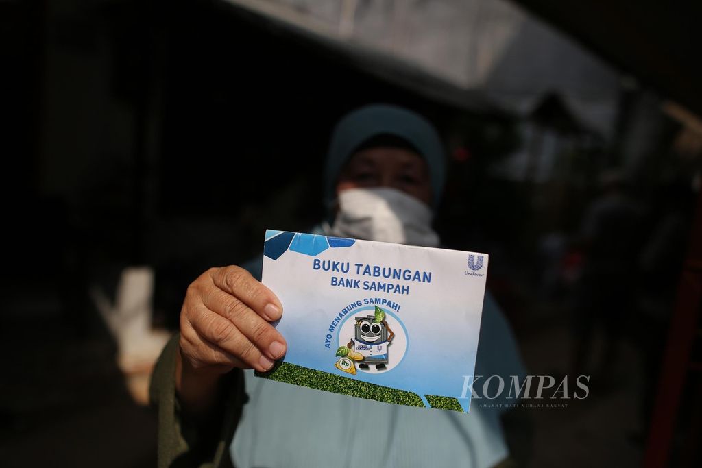 warga menunjukkan tabungan bank sampahnya setelah menjual sampah anorganik ke Bank Sampah Cempaka RW 005, Menteng Atas, Setiabudi, Jakarta Selatan, Selasa (21/76/2022).