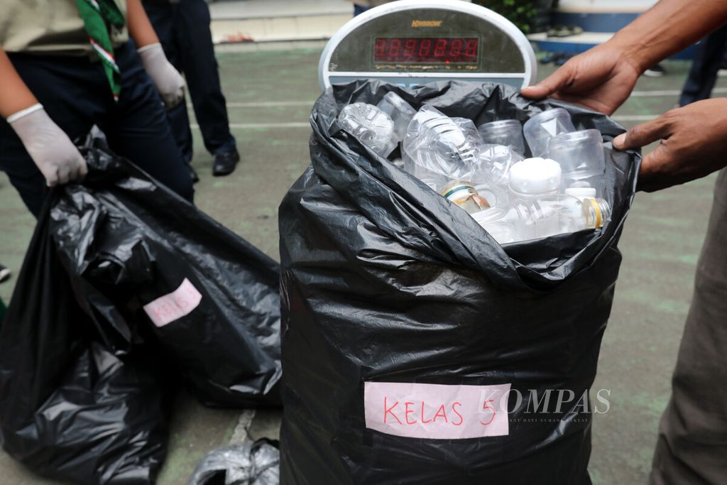 Petugas Bank Sampah Gunung Emas Pulo Kambing mengangkut karung sampah yang telah dipilah dan dikumpulkan siswa SD Muhammadiyah 09 Plus, Duren Sawit, Jakarta, Rabu (19/10/2022). Sampah tersebut dijemput oleh petugas dari Bank Sampah Gunung Emas Pulo Kambing.