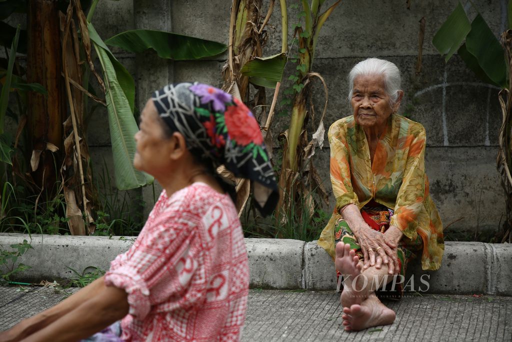 Anik (80) (kanan) dan Maria (70) berjemur di sekitar rusunawa Pesakih, Duri Kosambi, Kalideres, Jakarta Barat, Oktober 2020. Berjemur dilakukan oleh para lansia ini untuk memenuhi vitamin D tubuh yang penting bagi kesehatan tulang dan imunitas tubuh di tengah masa pandemi Covid-19. 